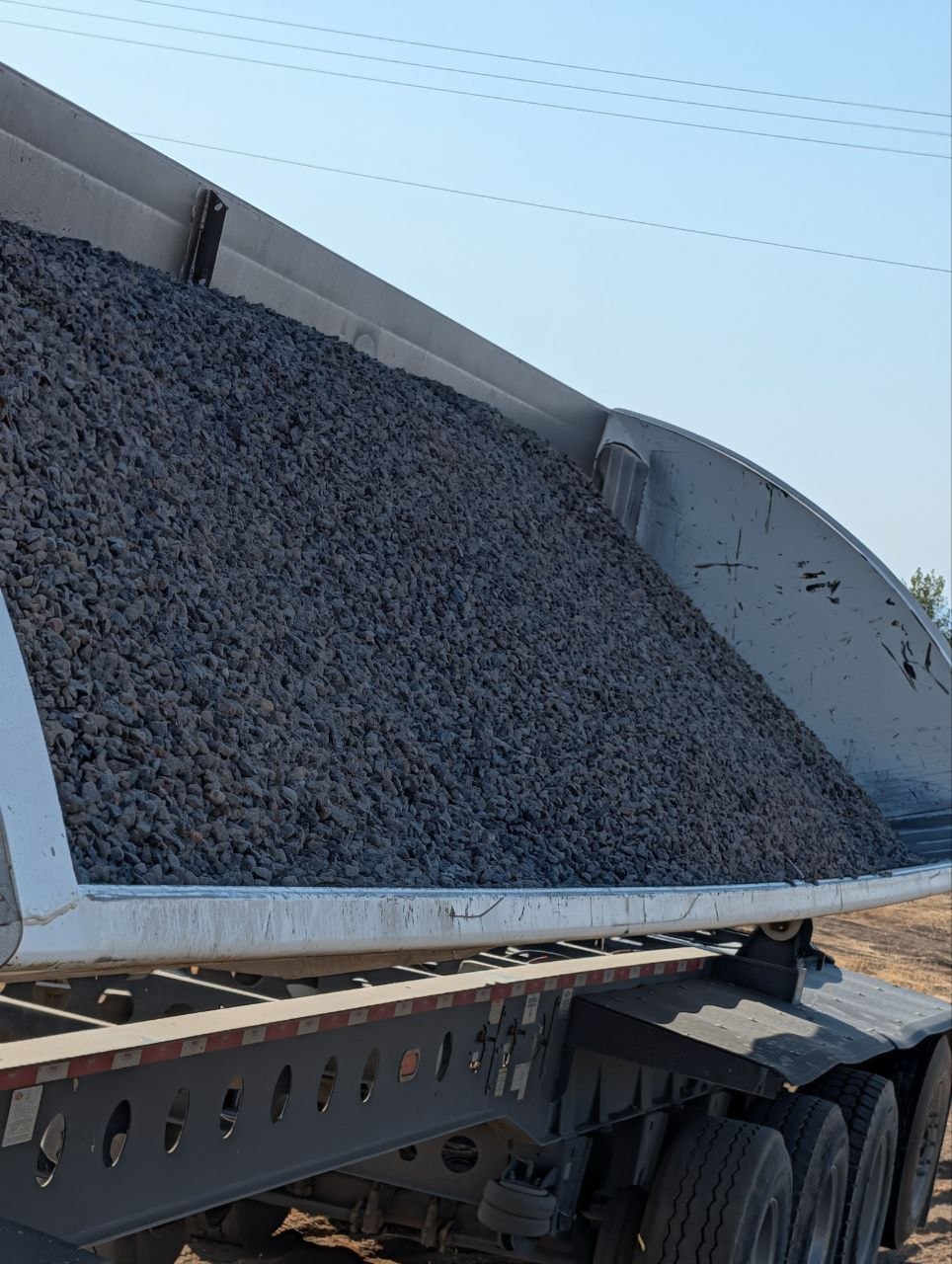 Side-dump trailer loaded with 3/4 gravel for delivery in West Jordan, Utah.